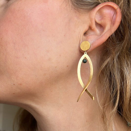 pendientes huecos ligeros con forma de pez y el ojo es de piedra natural africana verde. Son de acero hipoalergénico y resistente al agua. Son dorados y perfectos para looks casual de diario y para llevar en la piscina o en el mar.