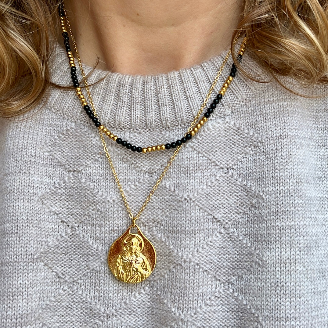 colgante con escapulario de la virgen del carmen y el sagrado corazón de jesús. El material es acero inoxidable, quirúrgico e hipoalergénico color oro. Es un collar religioso católico perfecto para regalar en una primera comunión a niños y niñas.