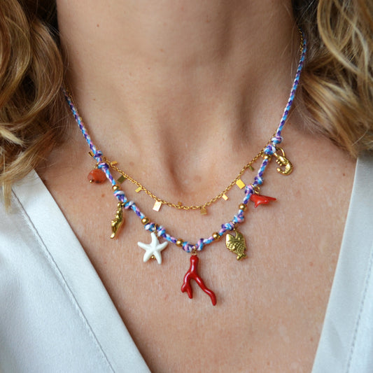COLLAR para verano de CORDÓN LILA con acero hipoalergénico y waterproof dorado. Los abalorios son coral, conchas, CABALLITO DE MAR y peces en dorado y rojo.