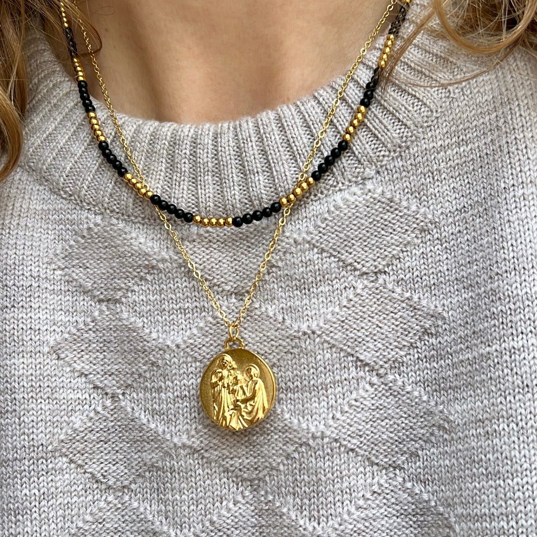 colgante con medalla de la sagrada familia. El material es acero inoxidable, quirúrgico e hipoalergénico color oro. Es un collar religioso católico perfecto para regalar en una primera comunión a niños y niñas.