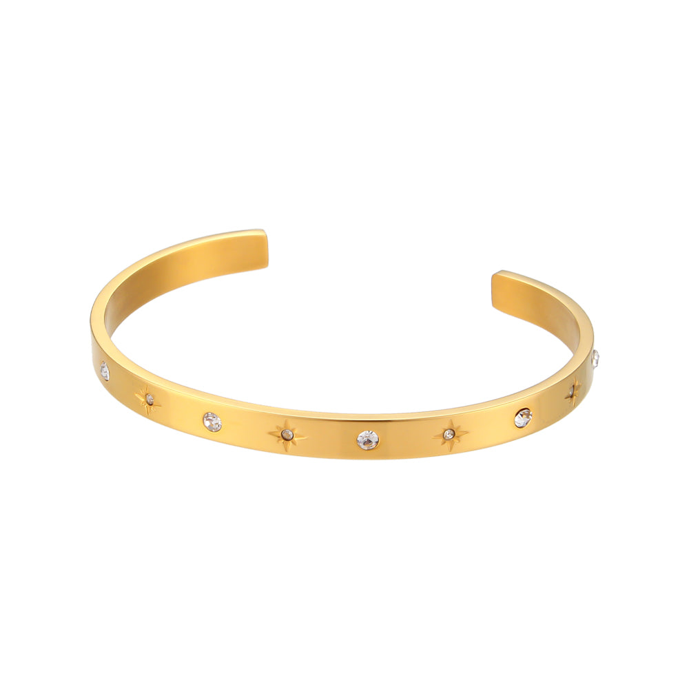 Pulsera o brazalete rígido tipo esclava resistente al agua. Está confeccionado en acero inoxidable con baño de oro 18 kilates o plata rodiada. tiene circonitas en forma de estrellas.Gold plated stainless Steel stiff or rigid waterproof rainbow zircon star bangle bracelet.