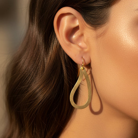 pendientes huecos ligeros con forma de ameba o estampado paisley. Son de acero hipoalergénico y resistente al agua. Son dorados y perfectos para looks casual de diario y para llevar en la piscina o en el mar.