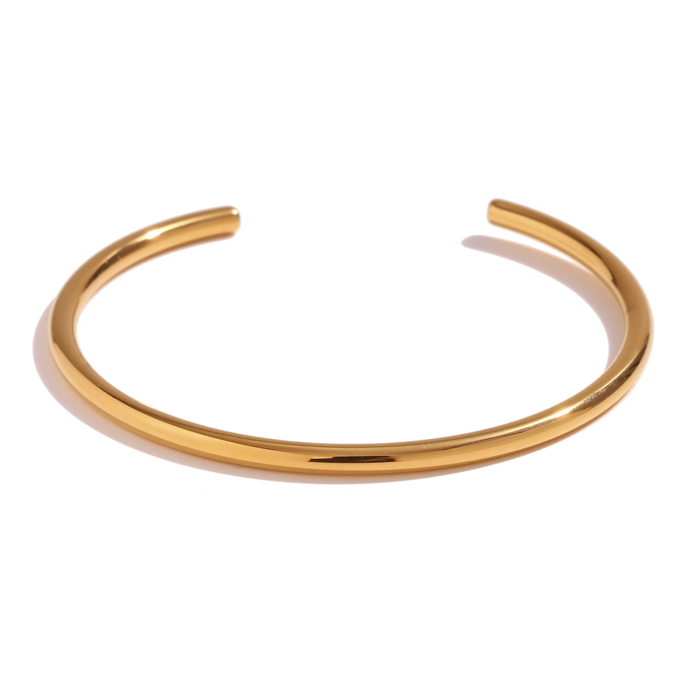 Pulsera o brazalete rígido y fino tipo esclava resistente al agua. Está confeccionado en acero inoxidable con baño de oro 18 kilates o plata rodiada. Gold plated stainless Steel stiff or rigid waterproof thin bracelet.