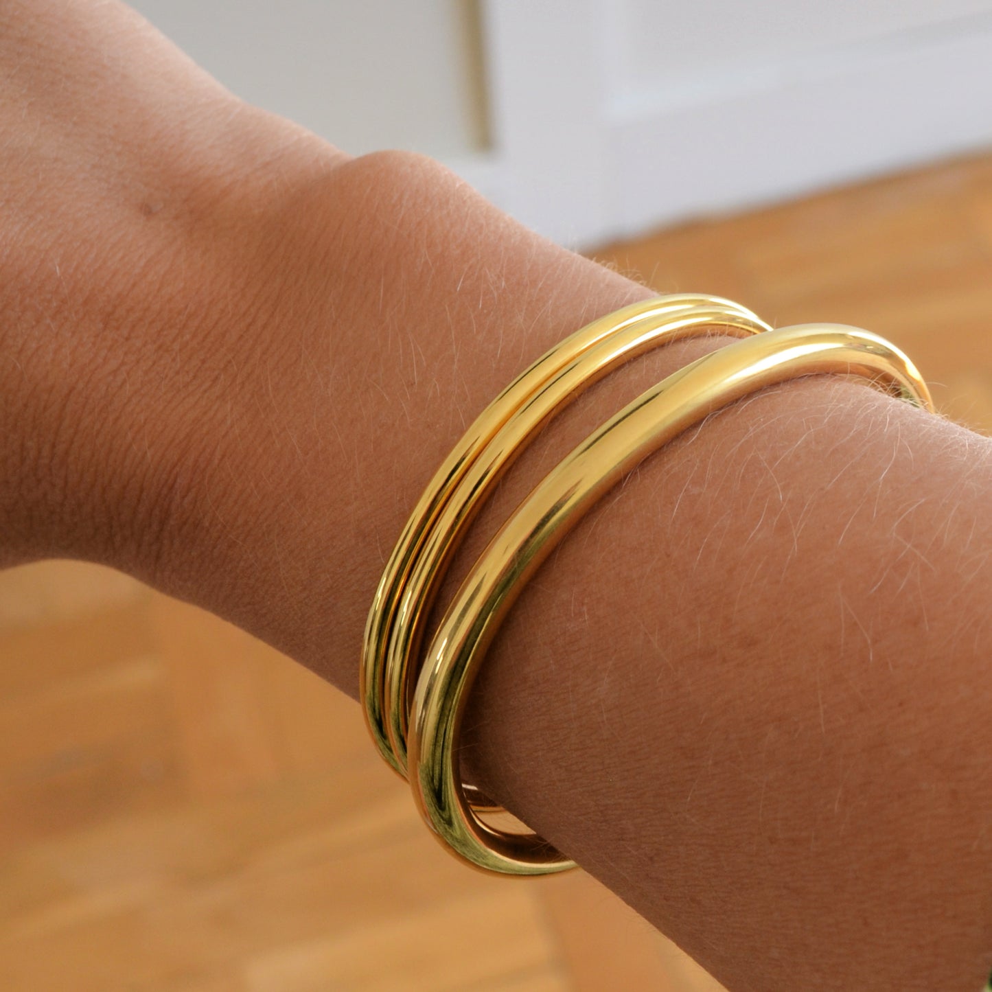 Pulsera o brazalete rígido tipo esclava resistente al agua. Está confeccionado en acero inoxidable con baño de oro 18 kilates o plata rodiada. Gold plated stainless Steel stiff or rigid waterproof bracelet.