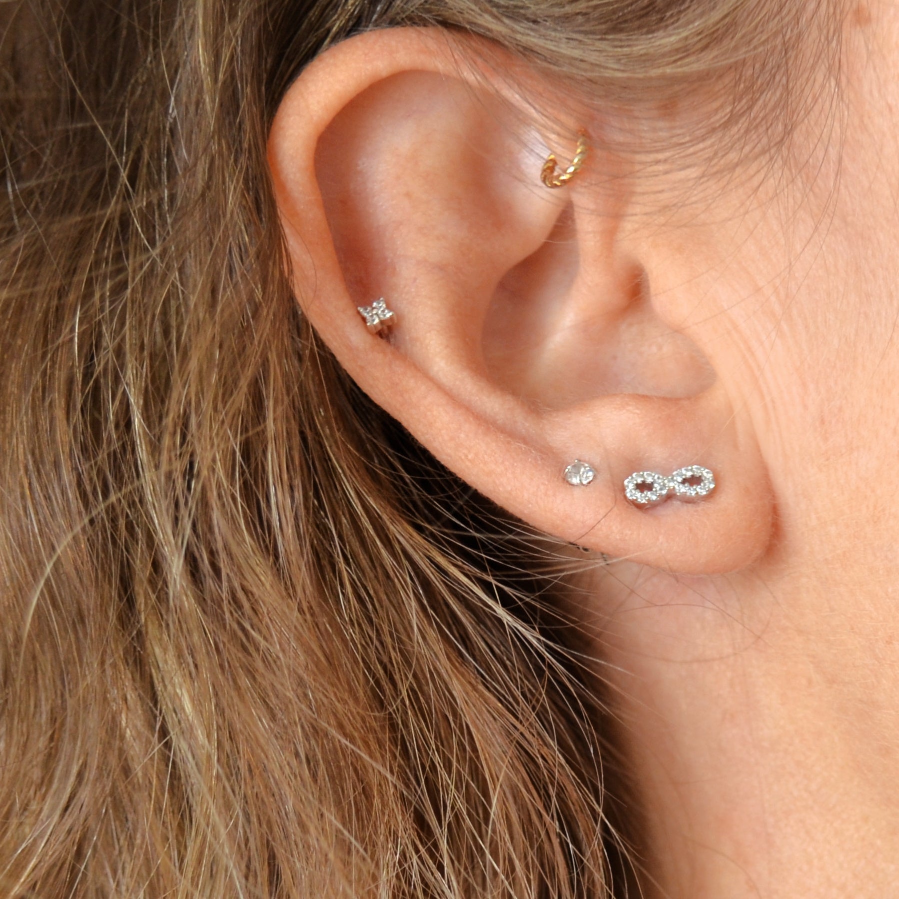 mini pendiente de piercing para cartílago anti alérgico. Está confeccionado en plata de ley con baño de oro 18 kilates y circonitas formando una flor pequeña. Gold plated sterling silver flower zircon piercing earring. Helix, tragus, anti helix.