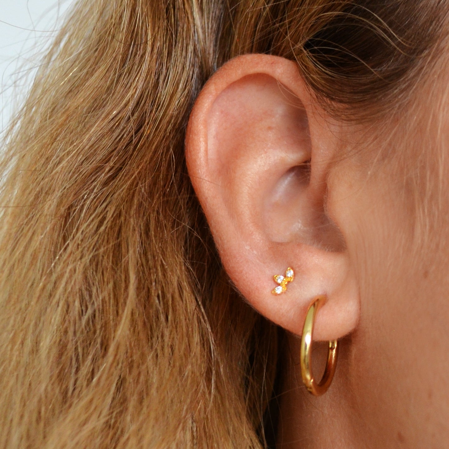 Mini pendientes pequeños de piercing con estrella y circonita confeccionados en plata de ley con baño de oro 18 kilates. Gold plated sterling silver piercing small earrings with zircon.
