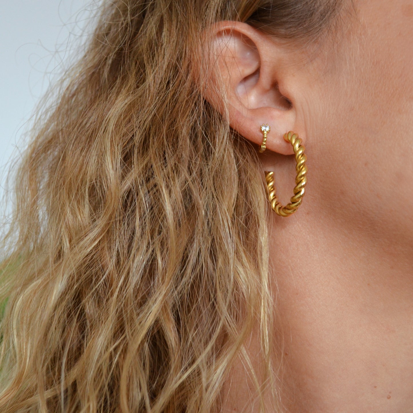 Aros criolla retorcidos en acero hipoalergénico bañado en oro resistente al agua. Gold plated stainless steel twisted waterproof hoop earrings