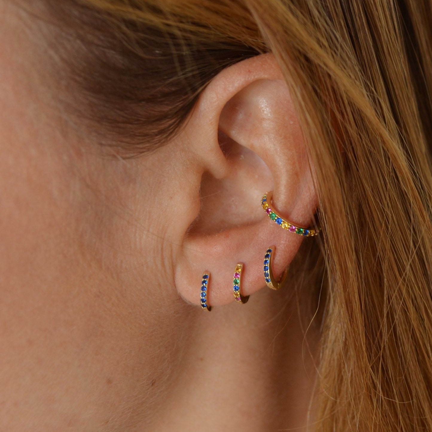 Pequeños pendientes de aro para niña o piercing de helix y tragus con circonitas multicolor confeccionados en plata de ley 925 con baño de oro 18 kilates. Gold plated sterling silver rainbow zircon small hoop earrings for piercing.