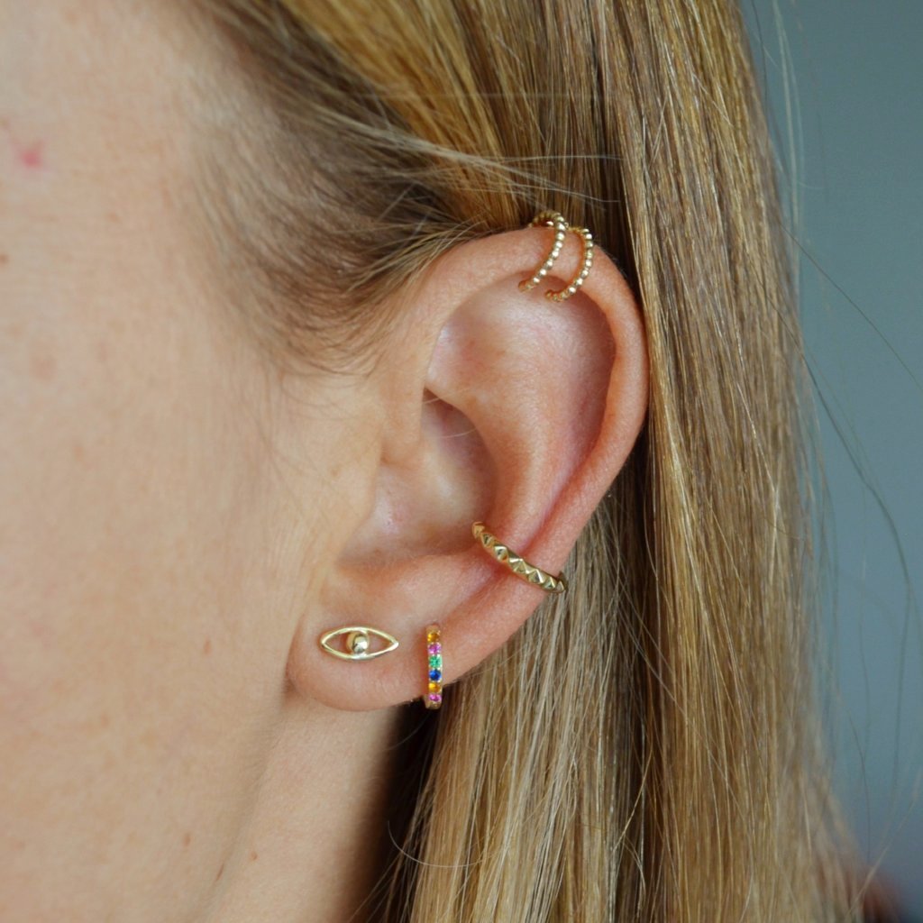 Pequeños pendientes de aro para niña o piercing de helix y tragus con circonitas multicolor confeccionados en plata de ley 925 con baño de oro 18 kilates. Gold plated sterling silver rainbow zircon small hoop earrings for piercing.