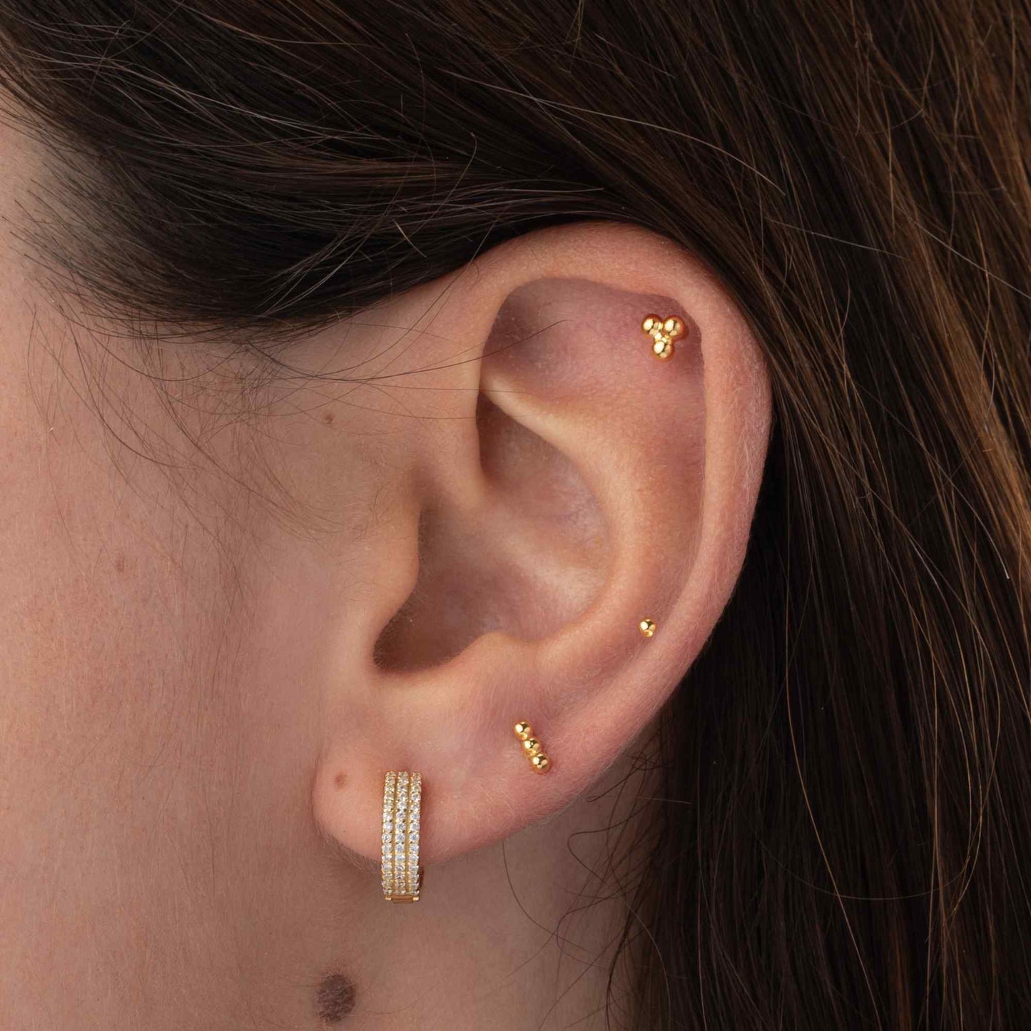 pequeño PIERcing de palito con bolitas hipoalergénico para cartílago de helix o tragus. Está confeccionado en plata de ley con baño de oro 18 kilates