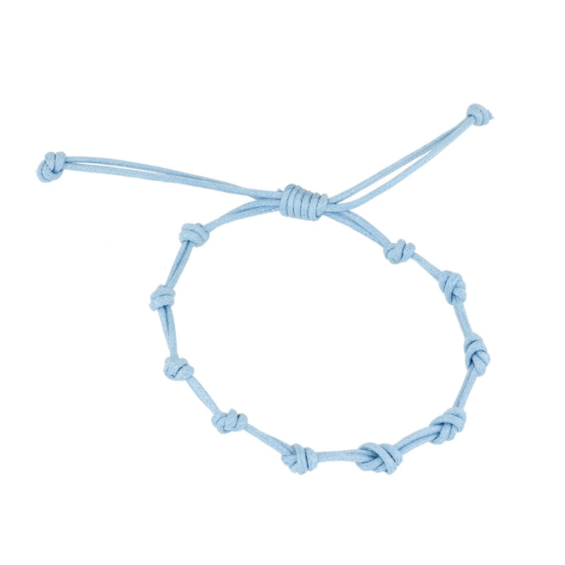 Pulsera para verano con nudos de color azul claro. Está confeccionada en cordón encerado con dos nudos. Se puede personalizar con un colgante de letra o charms de estrella, concha o luna. El cierre es ajustable.