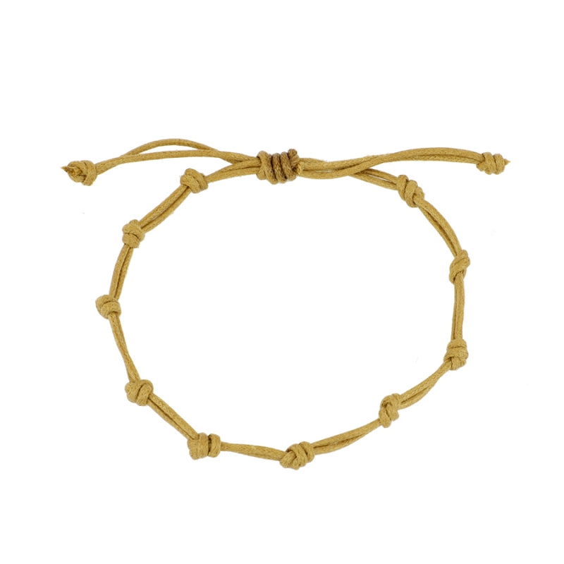 Pulsera para verano con nudos de color tostado o marrón claro. Está confeccionada en cordón encerado con dos nudos. Se puede personalizar con un colgante de letra o charms de estrella, concha o luna. El cierre es ajustable.