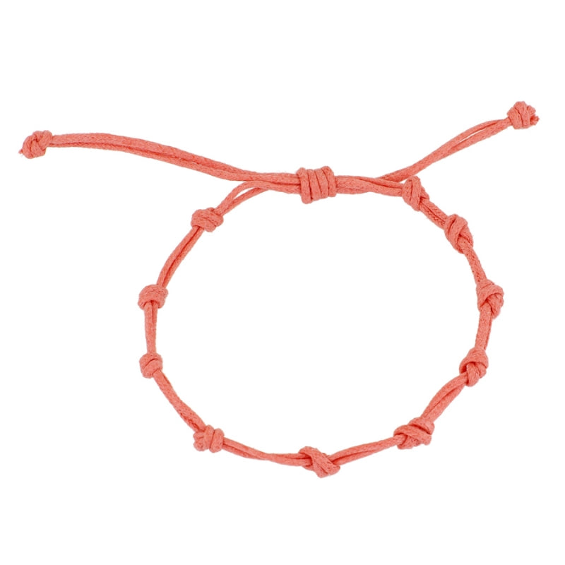 Pulsera para verano con nudos de color coral. Está confeccionada en cordón encerado con dos nudos. Se puede personalizar con un colgante de letra o charms de estrella, concha o luna. El cierre es ajustable.