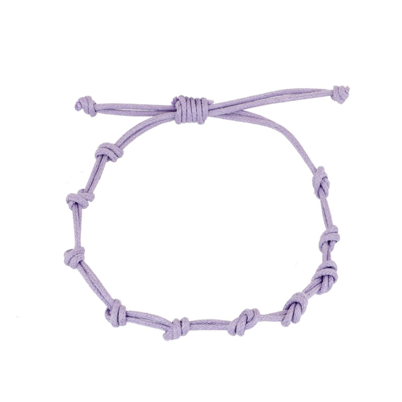 Pulsera para verano con nudos de color lila. Está confeccionada en cordón encerado con dos nudos. Se puede personalizar con un colgante de letra o charms de estrella, concha o luna. El cierre es ajustable.