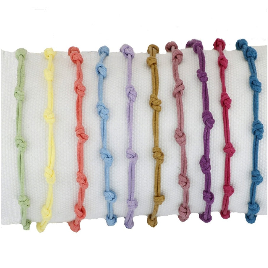 Pulsera para verano con nudos de colores. Está confeccionada en cordón encerado con dos nudos. Se puede personalizar con un colgante de letra o charms de estrella, concha o luna. El cierre es ajustable.