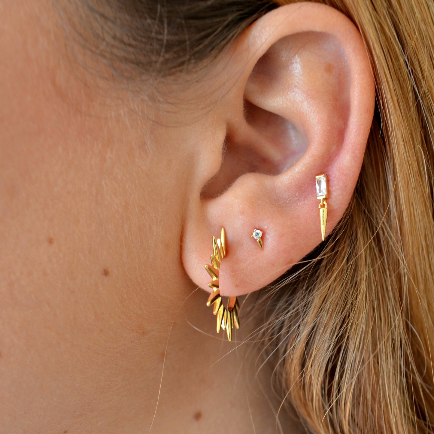 pendientes de piercing con circonita y colgante de pincho que están confeccionados en plata de ley con baño de oro 18 kilates