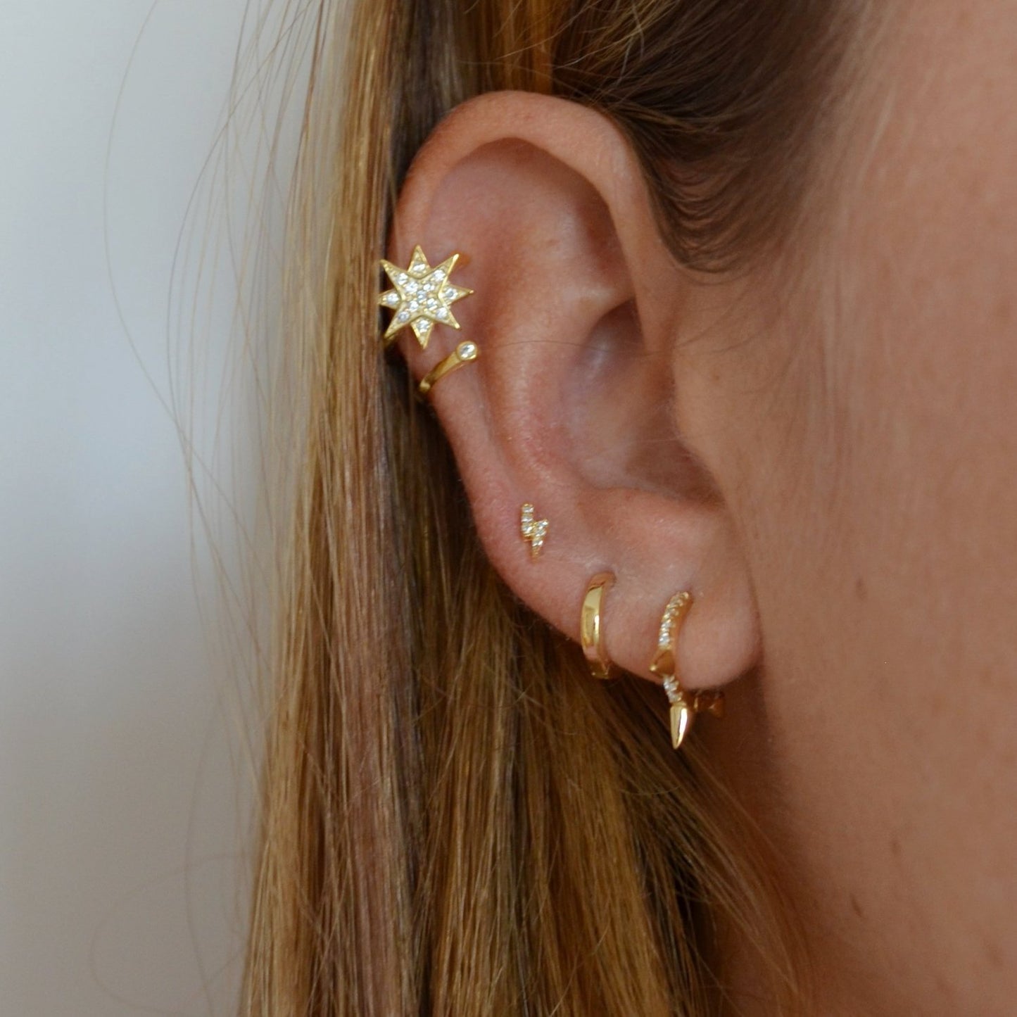 Pendientes mini o pequeños de rayo para niña o piercing de mujer confeccinados en plata de ley y baño de oro 18 kilates. Gold plated sterling silver zircon thunder earrings for piercing.