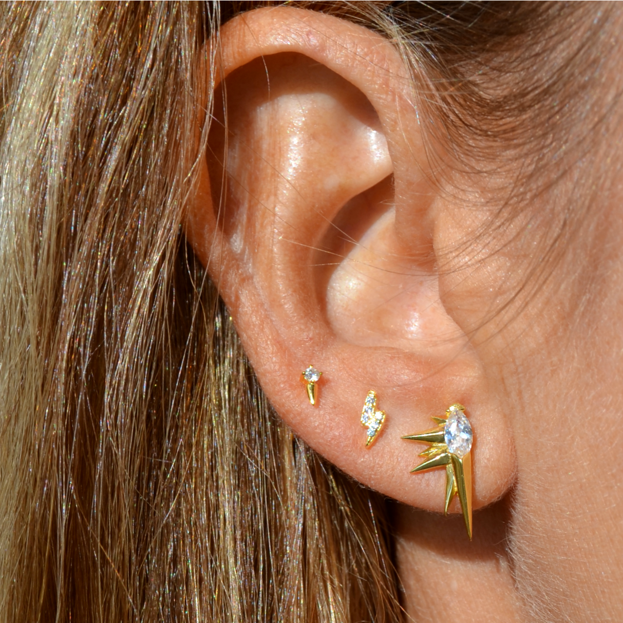 Pendientes mini o pequeños de rayo para niña o piercing de mujer confeccinados en plata de ley y baño de oro 18 kilates. Gold plated sterling silver zircon thunder earrings for piercing.