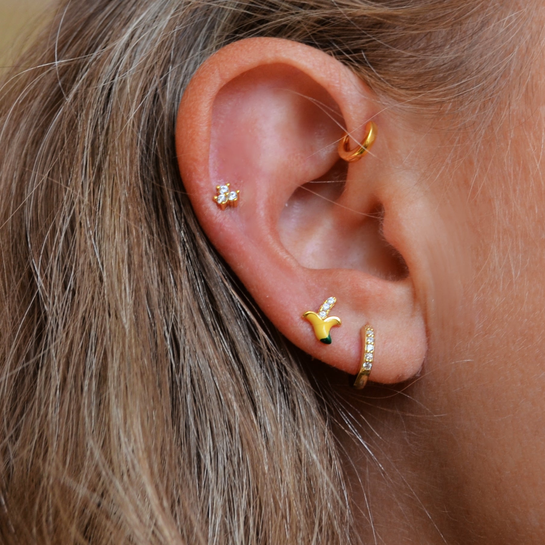 pequeño mini piercing de circonitas para cartílago de helix o tragus confeccionado en plata de ley con baño de oro 18 kilates