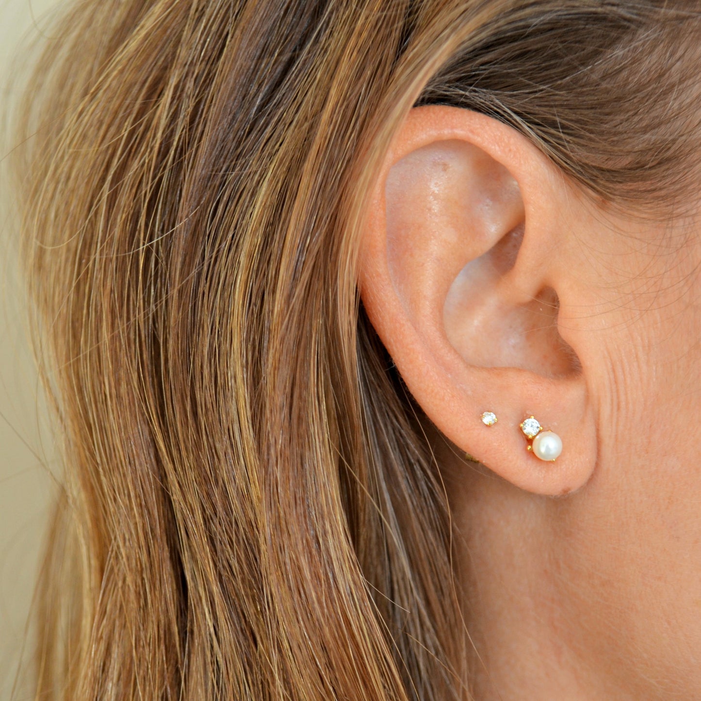 mini pendientes pequeños para niña con perla natural y circonita que están confeccionados en plata de ley con baño de oro 18 kilates. Small natural pearl and zircon earrings that are made of gold plated sterling silver and are perfect for a little girl