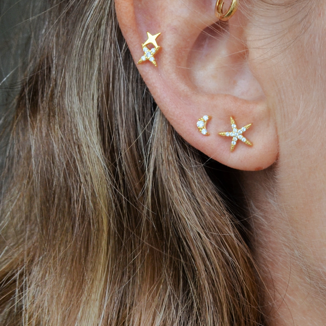 pendientes de piercing con dos estrellas de circonitas que está confeccionado en plata de ley con baño de oro 18 kilates y cierre de bola con rosca. Gold plated sterling silver zircon double star piercing earring
