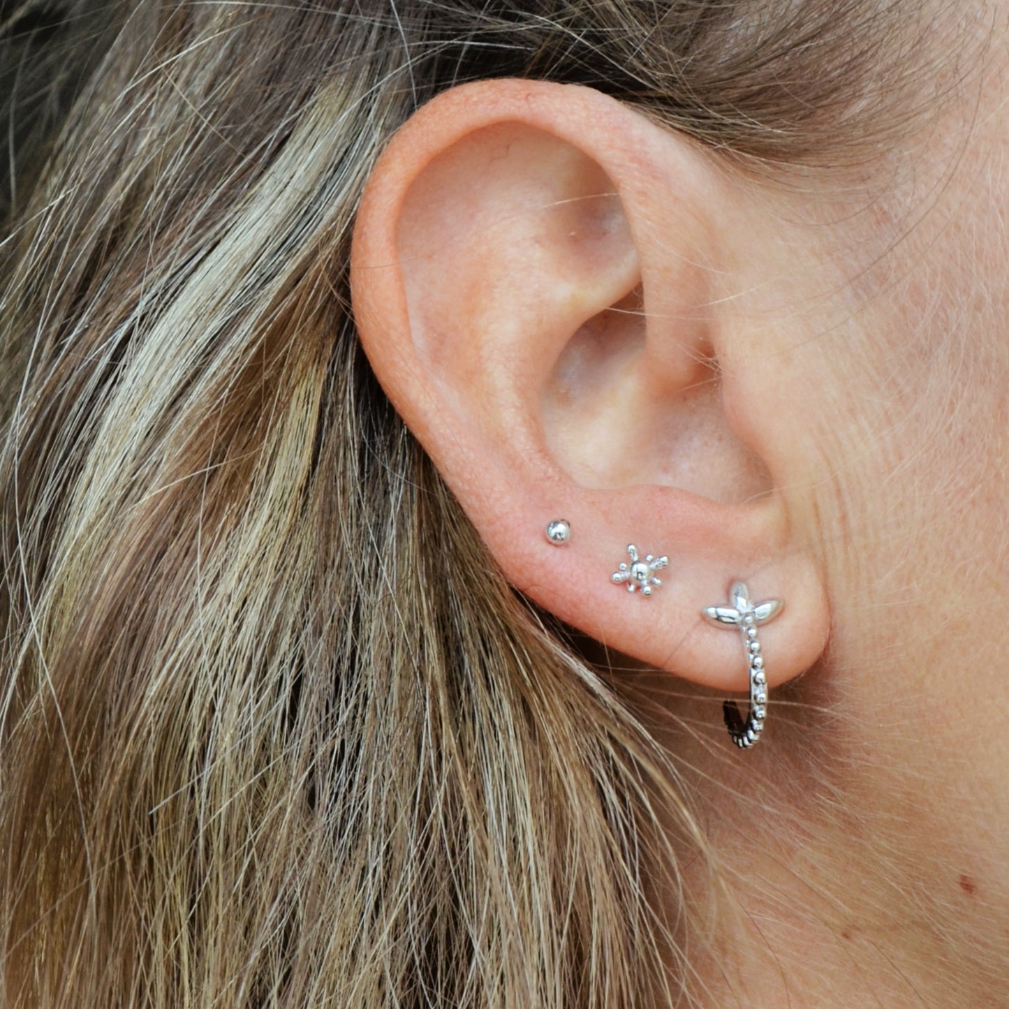 pendientes de medio aro abierto con flor de lis y bolitas confeccionados en plata de ley con baño de oro 18 kilates. Gold plated sterling silver open hoop earrings