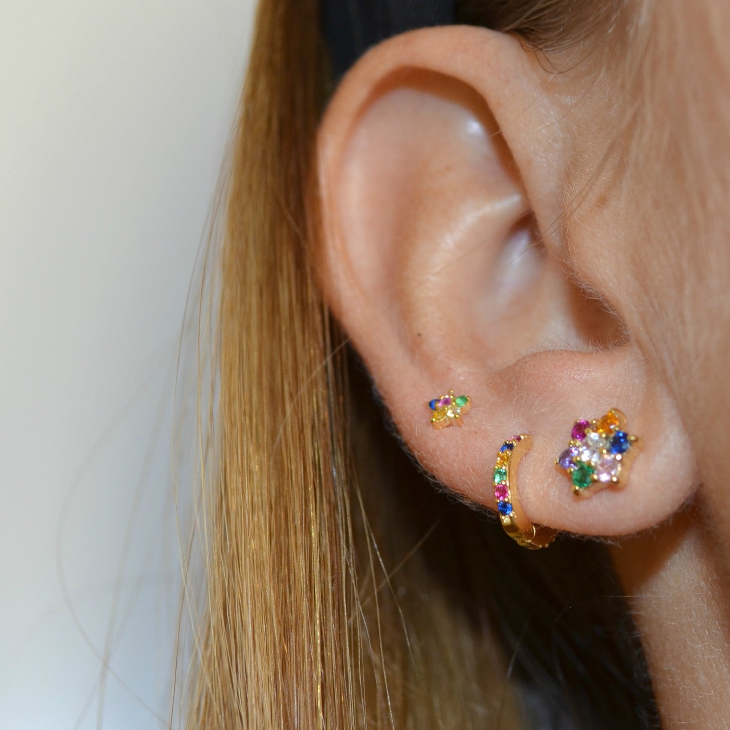 Pequeños pendientes de aro para niña o piercing de helix y tragus con circonitas multicolor confeccionados en plata de ley 925 con baño de oro 18 kilates. Gold plated sterling silver rainbow zircon small hoop earrings for piercing.