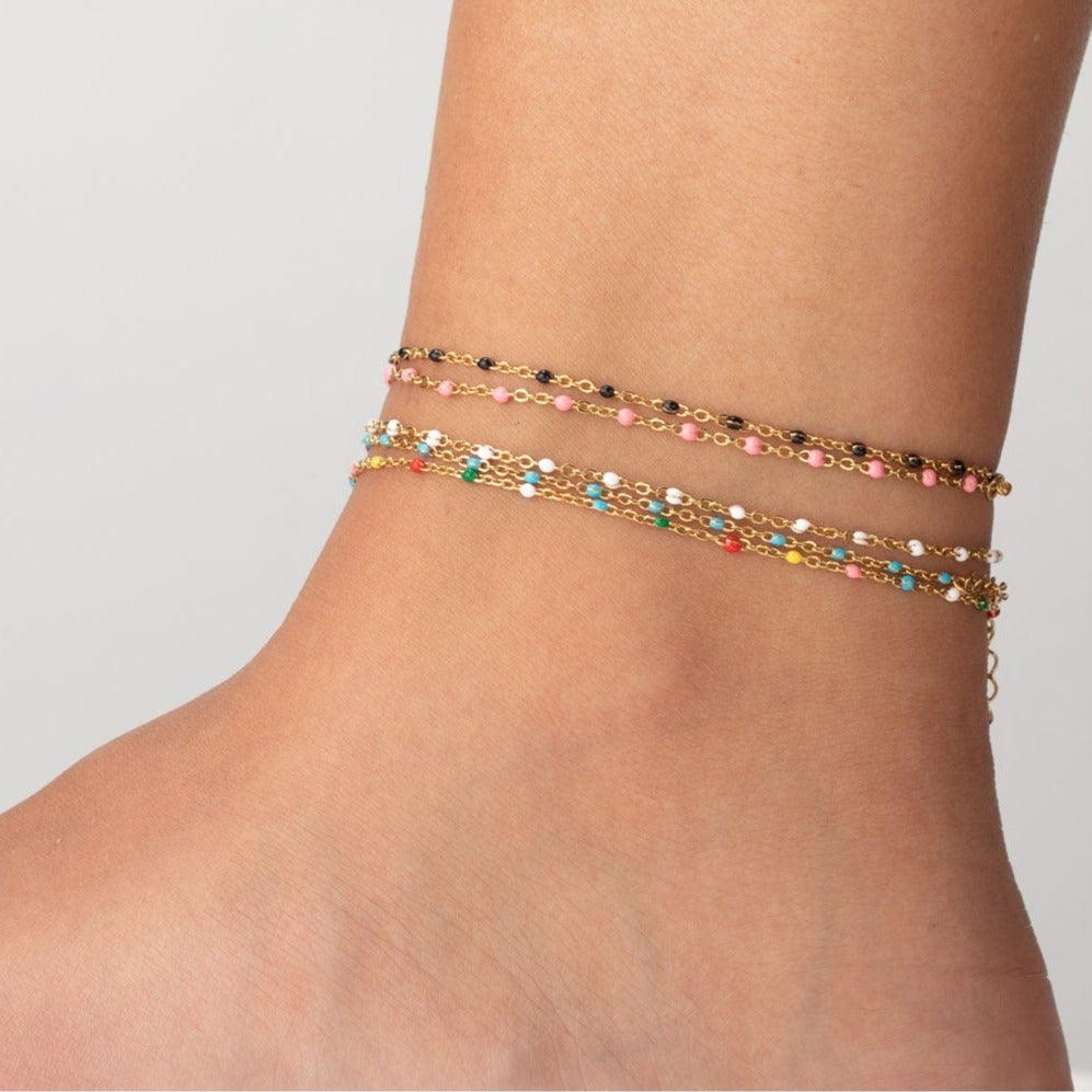 tobillera waterproof o resistente al agua confeccionada en acero con baño de oro de 3 micras. Tiene bolitas de enamel color blanco y el cierre es ajustable. golden stainless steel white bead anklet chain