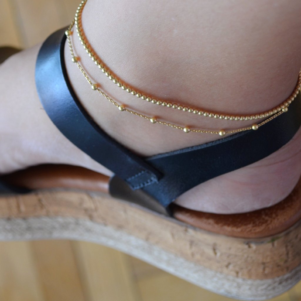 Tobillera de bolitas confeccionada en cadena de plata de ley con baño de oro 18 kilates. Gold plated sterling silver bead anklet.