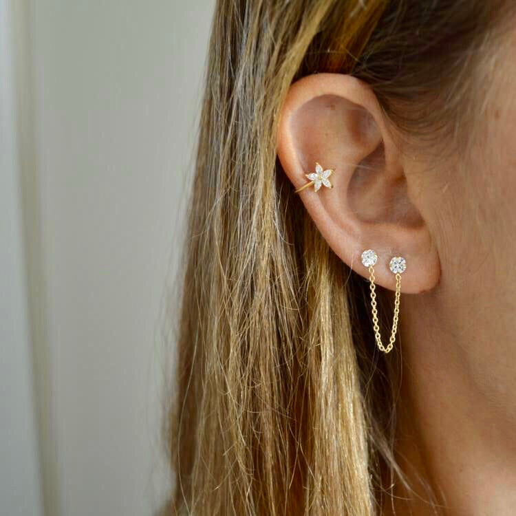 Pendientes pequeños de piercing con brillantes unidos por una cadena confeccionados en plata de ley con baño de oro 18 kilates