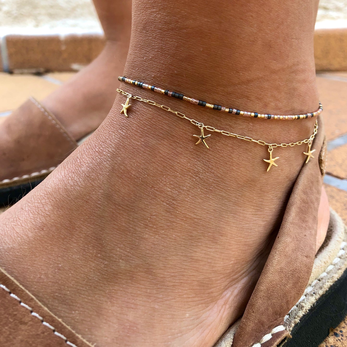 tobillera de plata de ley con baño de oro y 6 estrellas de mar. Gold plated silver anklet with starfish charms.