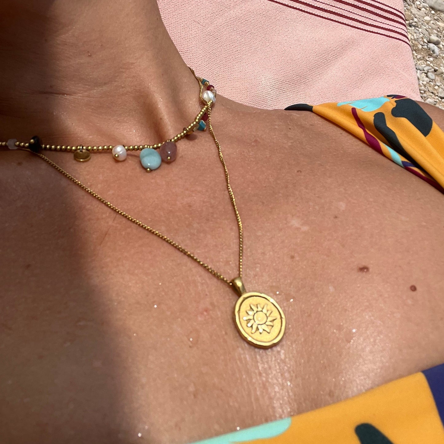 gargantilla de cadena larga con medalla del sol y la luna. Es de acero hipoalergénico bañado en oro y resistente al agua. Gold plated stainless steel waterproof sun and moon pendant necklace for layering