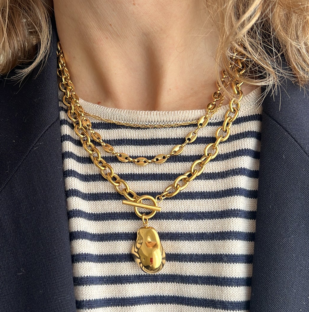 collar dorado o plata de eslabón grueso o gordo confeccionado en acero HIPOALERGÉNICO y resistente al agua. Tiene un colgante en forma de piedra. 