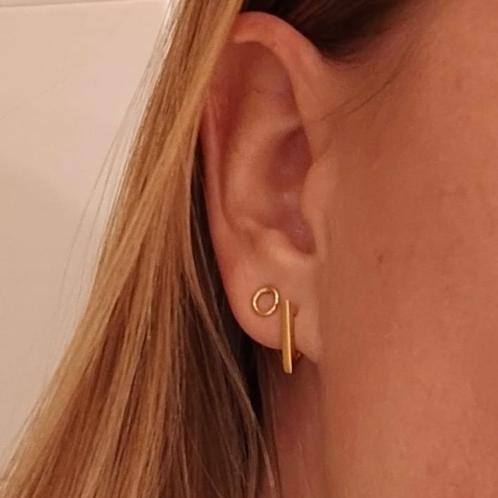 pendientes de aro con forma de triángulo para piercing que están confeccionados en plata de ley con baño de oro 18 kilates. gold plated silver triangle hoop earrings for piercing.