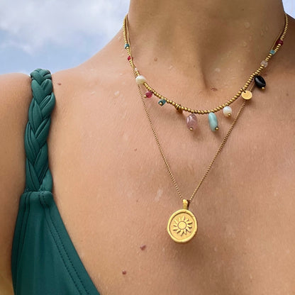 gargantilla de cadena larga con medalla del sol y la luna. Es de acero hipoalergénico bañado en oro y resistente al agua. Gold plated stainless steel waterproof sun and moon pendant necklace for layering