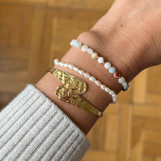 Pulsera o brazalete ajustable y fino resistente al agua. Está confeccionado en acero inoxidable dorado con relieve. Es perfecto para looks de invitada a boda o fiestas de noche boho. Gold plated stainless Steel adjustable waterproof bracelet.