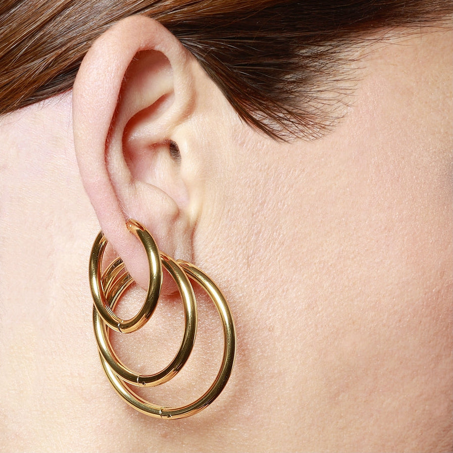Aros básicos grandes de piercing con cierre fácil resistentes al agua. Son hipoalergénicos y están confeccionados en acero inoxidable con baño de oro 18 kilates. Gold plated stainless steel waterproof hoop earrings for piercing.