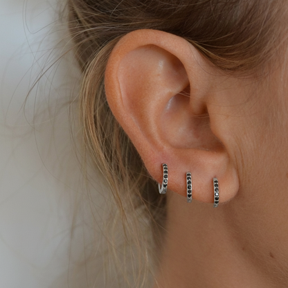 Pequeños pendientes de aro para piercing en helix o tragus con circonitas negras confeccionados en plata de ley 925 con baño de oro 18 kilates