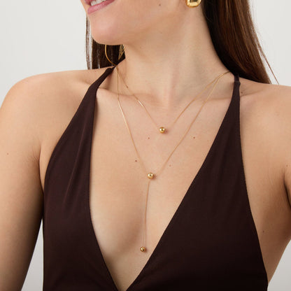 collar largo boho para adolescente o mujer joven que lleve escote en v o escote pronunciado. es de cadena larga con bolas colgantes. ideal para looks de noche o de fiesta. Es de acero hipoalergénico dorado o plateado y resistente al agua