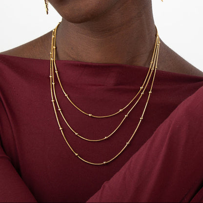 collar triple boho para adolescente o mujer joven que lleve escote palabra de honor, escote en v o escote pronunciado. es de 3 cadenas con bolitas. ideal para looks de noche o de fiesta. Es de acero hipoalergénico dorado o plateado y resistente al agua