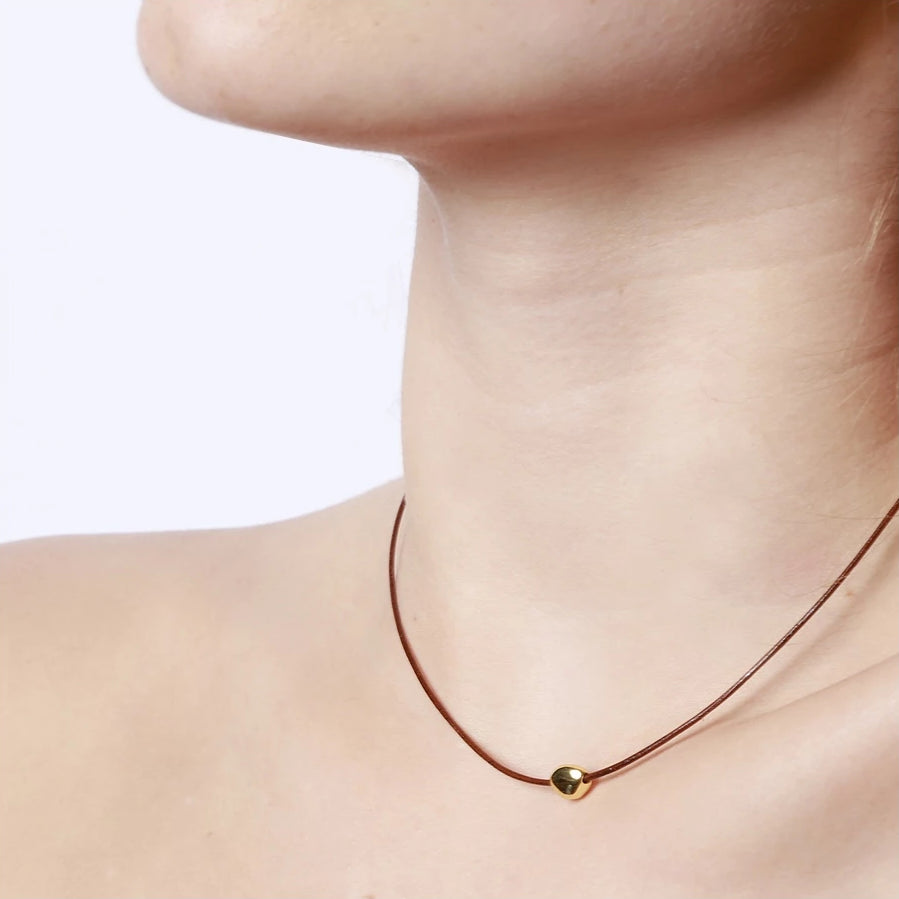 collar de hilo o cordón en color marrñon con bolita plateada o dorada. Gold plated sterling silver bead brown thread necklace.