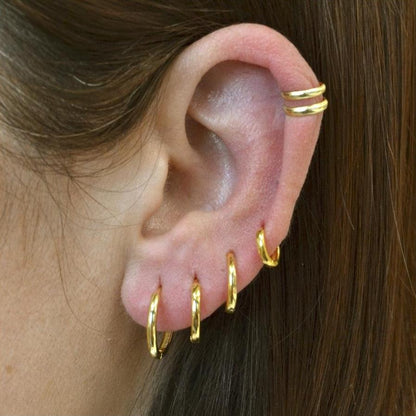 ear cuff cruzado en plata de ley 925 con baño de oro 18 kilates para llevar como un pendiente en el cartílago sin agujero. Gold plated silver ear cuff pack for piercing imitation