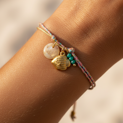 pulsera waterproof o resistente al agua confeccionada con cordón dorado y rosa con abalorios de piedra natural y acero dorado.  Cierre ajustable, colgante de concha, pez, cangrejo y abalorios de colores (CORAL, azul TURQUESA, naranja)