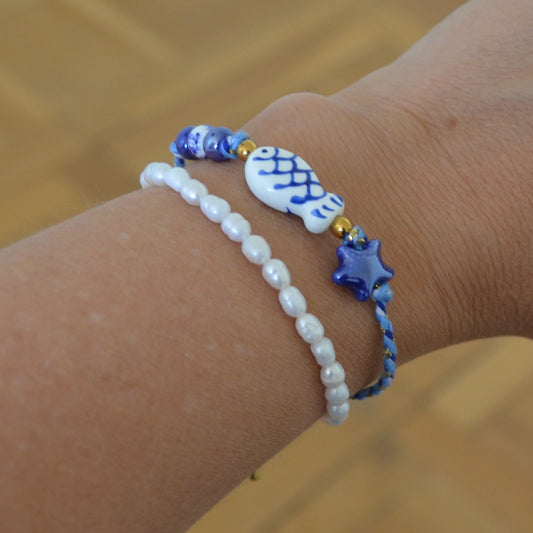 pulsera DE VERANO waterproof o resistente al agua confeccionada con cordón de algodón, abalorios de cerámica y acero dorado.  Cierre ajustable, colgante de estrella de mar y pez azul y blanco. Ideal para regalar a mujeres, niñas y adolescentes en vacaciones.