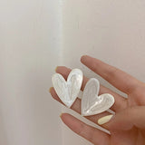 grandes pendientes de corazón blanco y dorado para invitada a boda o fiesta. Gold plated white big heart stud earrings.
