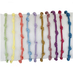 Pulsera para verano con nudos de colores. Está confeccionada en cordón encerado con dos nudos. Se puede personalizar con un colgante de letra o charms de estrella, concha o luna. El cierre es ajustable.