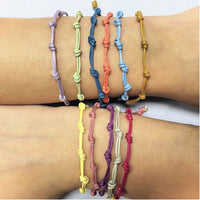 Pulsera para verano con nudos de colores. Está confeccionada en cordón encerado con dos nudos. Se puede personalizar con un colgante de letra o charms de estrella, concha o luna. El cierre es ajustable.