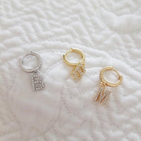 pendientes de aro con letra inicial para piercing que están confeccionados en plata de ley con baño de oro 18 kilates. gold plated silver initial letter hoop earrings for piercing.