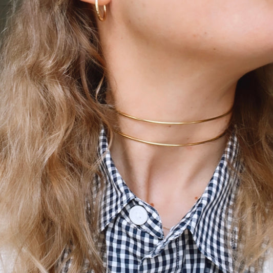   COLLAR rígido doble tipo choker waterproof o resistente al agua confeccionado en acero inoxidable con baño de oro 18 kilates. Tiene dos aros rígidos y es ajustable al cuello. Gold plated stainless Steel adjustable double ring choker necklace.